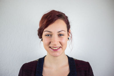 Portrait of a smiling young woman against white background