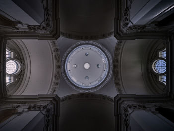 The ceiling of a baroque church with a circular opening and windows in symmetry in salzburg, austria