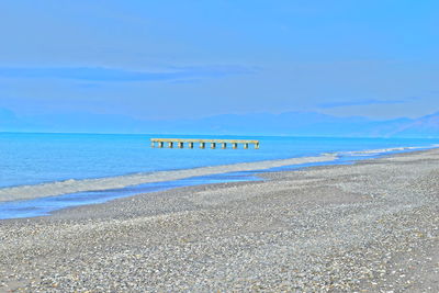 Scenic view of beach against blue sky