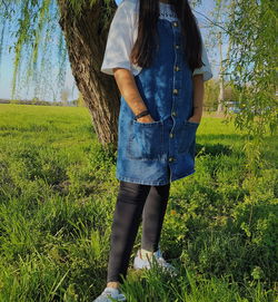 Low section of teenage girl standing on field