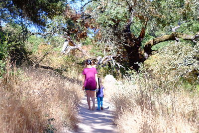 Rear view of girl walking on tree