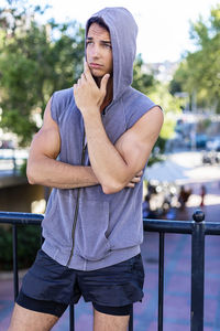 Young man standing by railing