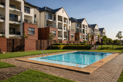 View of swimming pool by building against sky