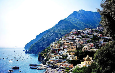 Aerial view of townscape by sea against sky