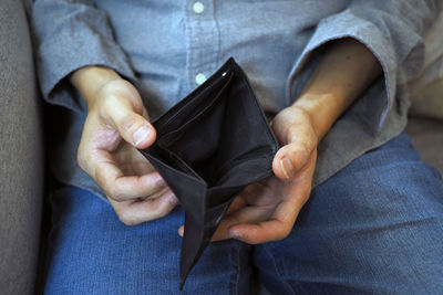 Midsection of man holding empty wallet