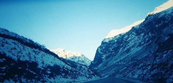 Scenic view of snow mountains against clear blue sky