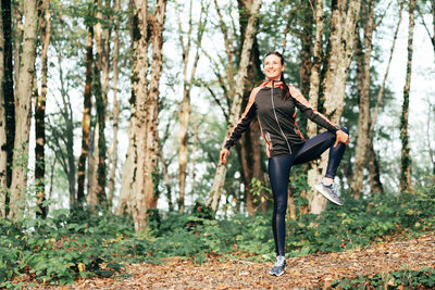 Full length of woman standing in forest