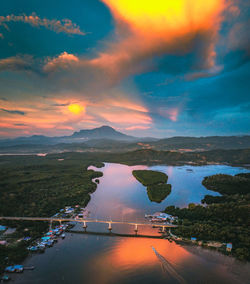 Scenic view of river against sky at sunset