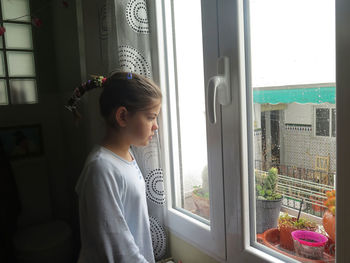 Girl looking out the window on a rainy day