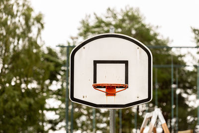 Basketball hoop against trees in city