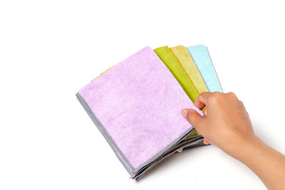 Low section of person holding book against white background