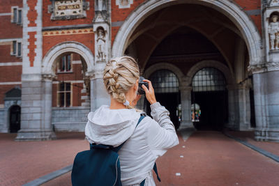 Young woman standing against building