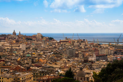 Aerial view of townscape by sea against sky