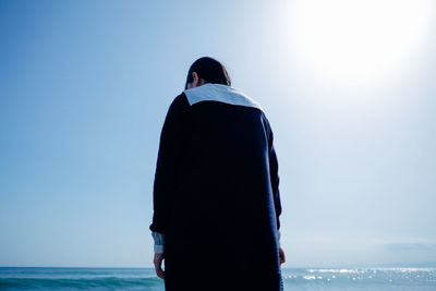 Rear view of woman standing on beach