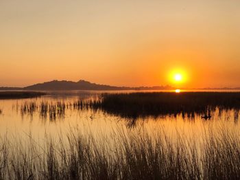 Scenic view of lake against sky during sunset