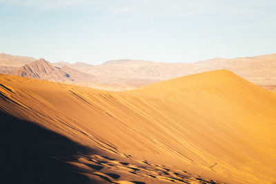 Scenic view of sand dunes in desert against sky