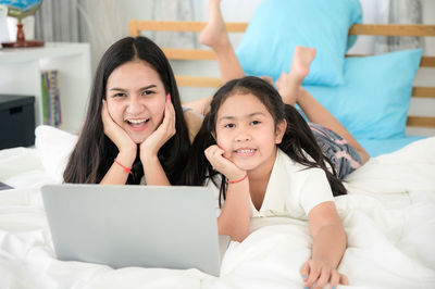 Portrait of smiling girl on bed at home