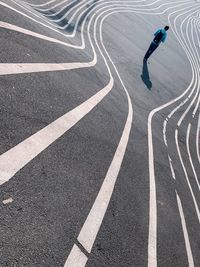 High angle view of man walking on zebra crossing