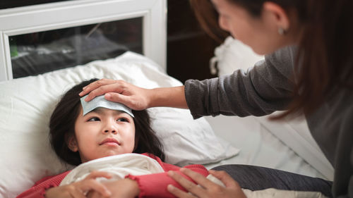 Midsection of woman lying down on bed