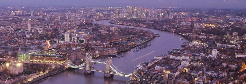 High angle view of illuminated city at riverbank