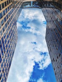 Low angle view of buildings against cloudy sky