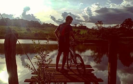 REAR VIEW OF MAN WITH BICYCLE STANDING ON MOUNTAIN