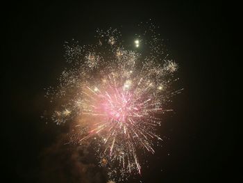Low angle view of firework display against sky at night