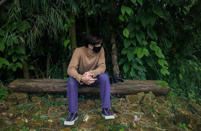 Full length of young man sitting on land