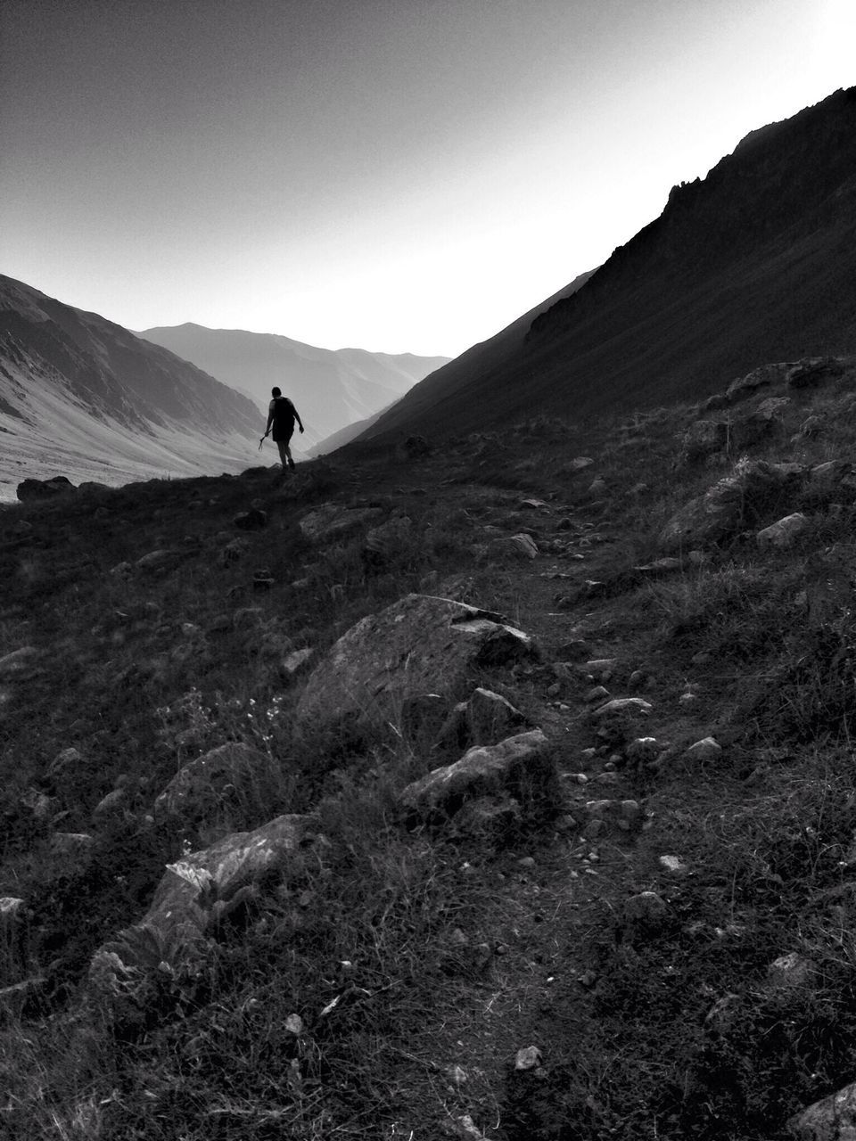 mountain, mountain range, lifestyles, leisure activity, landscape, men, full length, tranquil scene, tranquility, clear sky, hiking, rear view, scenics, nature, beauty in nature, walking, non-urban scene, adventure