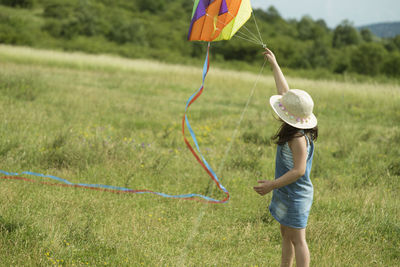 Full length of woman wearing hat standing on field