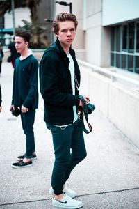 Rear view of a young man walking on sidewalk