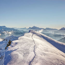 Scenic view of snowcapped mountains against clear blue sky