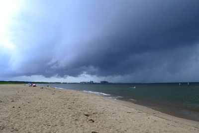 Scenic view of beach against cloudy sky