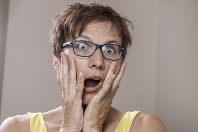 Close-up portrait of shocked woman at home