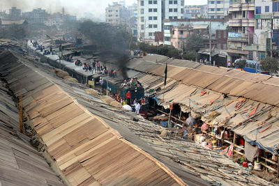 High angle view of train running inside a busy market in city