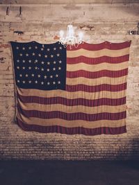 Illuminated chandelier by american flag on wall