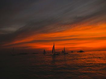 Silhouette sailboat on sea against sky during sunset