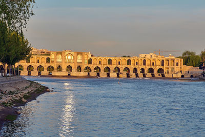 View of river by building against sky