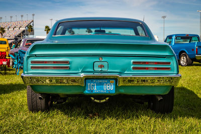 Vintage car on field against blue sky