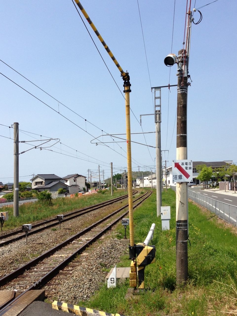 railroad track, clear sky, power line, electricity pylon, transportation, rail transportation, power supply, fuel and power generation, electricity, cable, blue, built structure, connection, sky, building exterior, road, public transportation, day, architecture, power cable