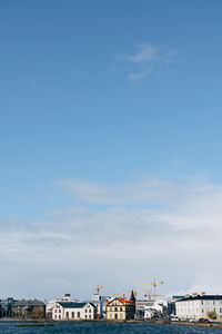 View of harbor by buildings against sky