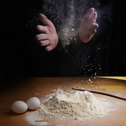 Cropped hands of man preparing food on table