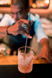 Close-up of bartender holding drink on table