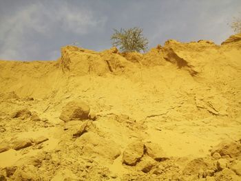 Scenic view of desert against cloudy sky