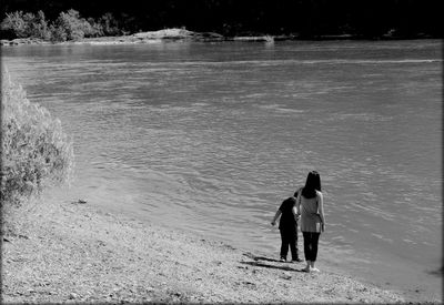 Rear view of couple walking on beach