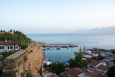 High angle view of townscape by sea against clear sky