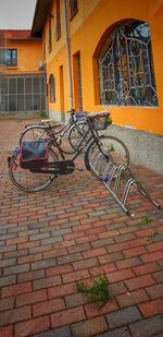 Bicycle parked on footpath by building