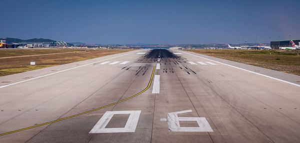 Road marking on airport runway against sky
