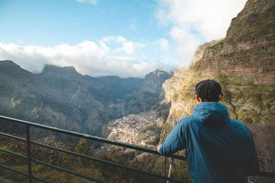 Man look out over the village of curral das freiras wedged in the mountains on the island of madeira