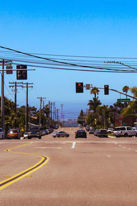 Cars on street against cloudy sky